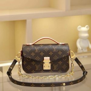 The East West Métis handbag features a stylish shoulder bag silhouette with a trendy aesthetic. Crafted from the brand's Monogram canvas, this compact piece boasts a distinctive S-lock clasp and a chic top handle, with a polished surface that gleams brilliantly. Versatile and spacious, it includes a detachable long shoulder strap for comfortable crossbody or shoulder carry. An ideal companion for everyday outings. Dimensions: 21.5 x 6 x 13.5 cm